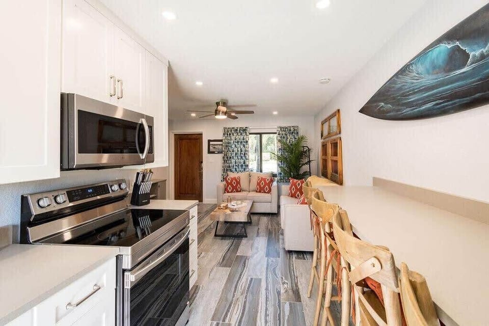 Modern kitchen and living area with bar seating and natural light.