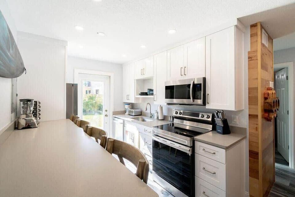 Bright modern kitchen with stainless steel appliances and a breakfast bar.