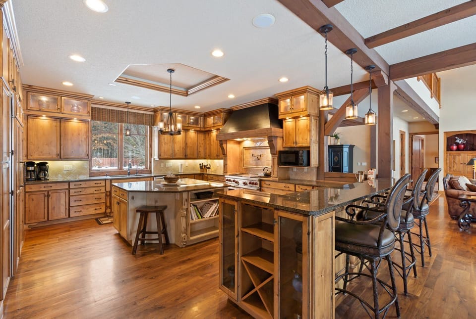 Cook memorable meals in your gourmet kitchen with professional appliances, granite counters, and rustic wood beams overhead.