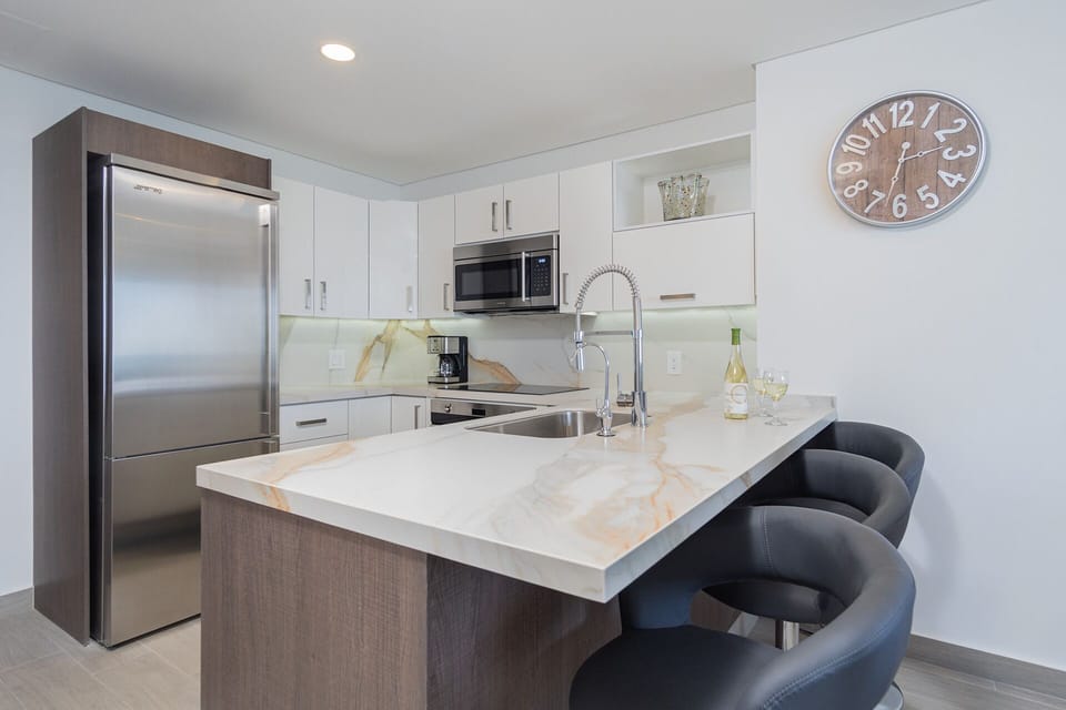 There are three high backed bar stools at the kitchen counter.