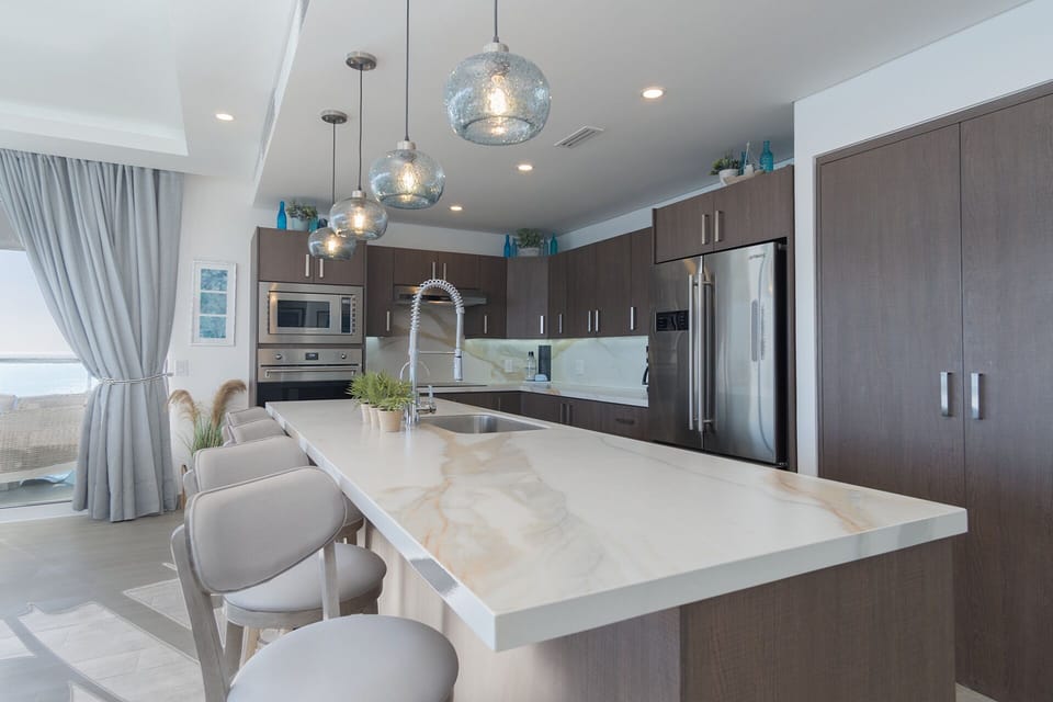 The kitchen has a sizable kitchen island, and custom drop lights.