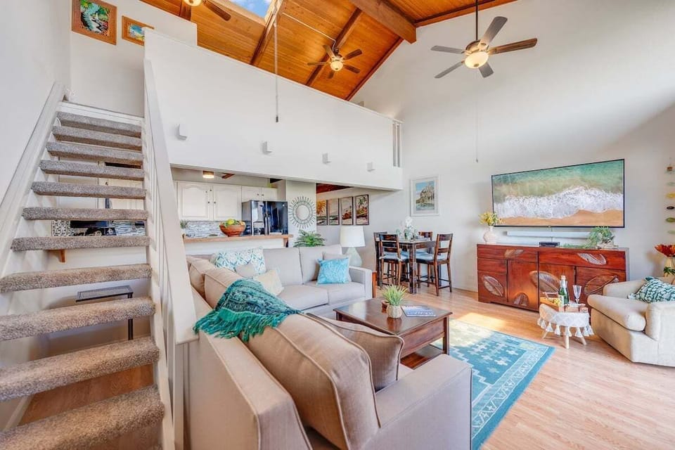 Bright open‑concept living room with sleeper sofa and coastal décor.