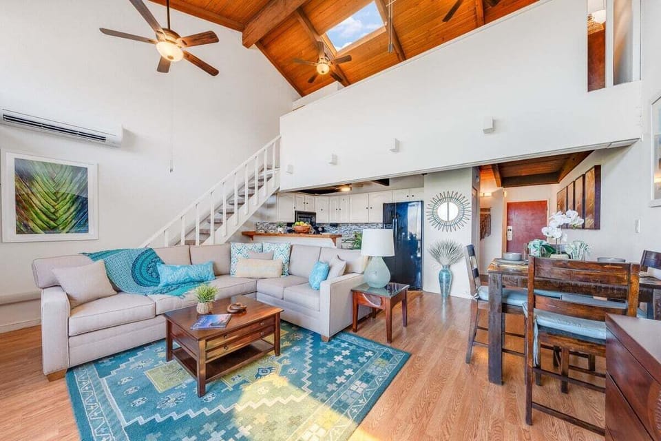 Airy living room with vaulted ceilings and comfortable seating areas.
