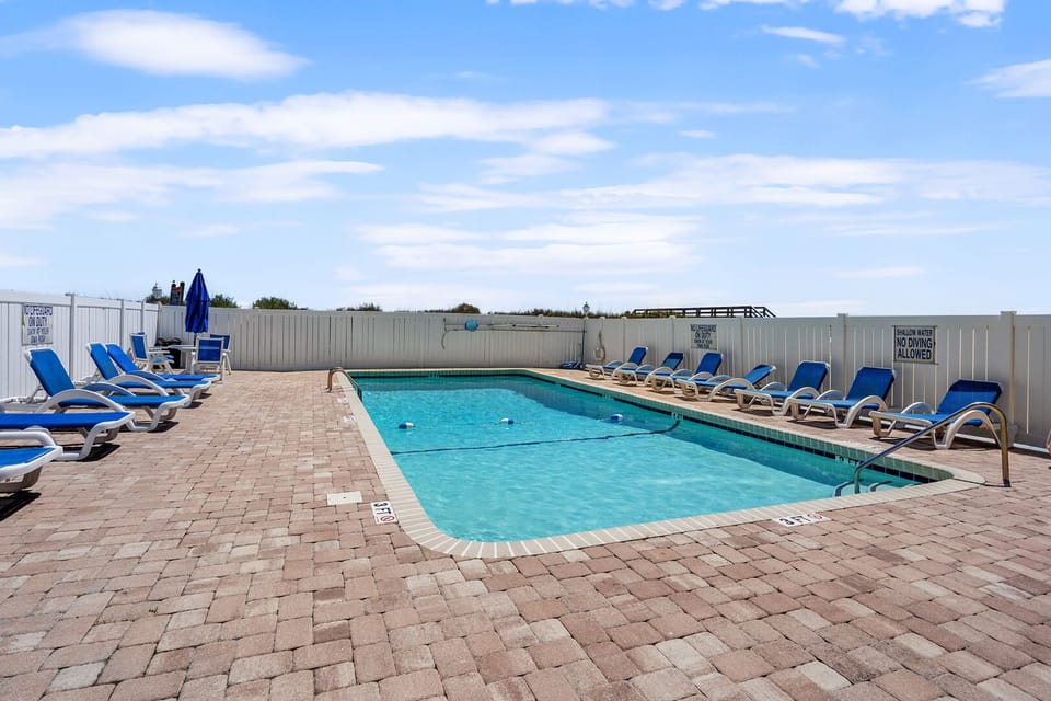 Poolside lounge chairs on the patio at Sedgefield 403, a 3-bedroom Cherry Grove rental