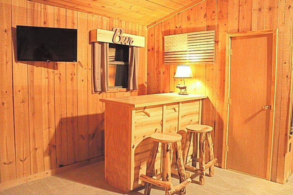 Dry bar with stools, flat screen tv in the pool table and loft area  