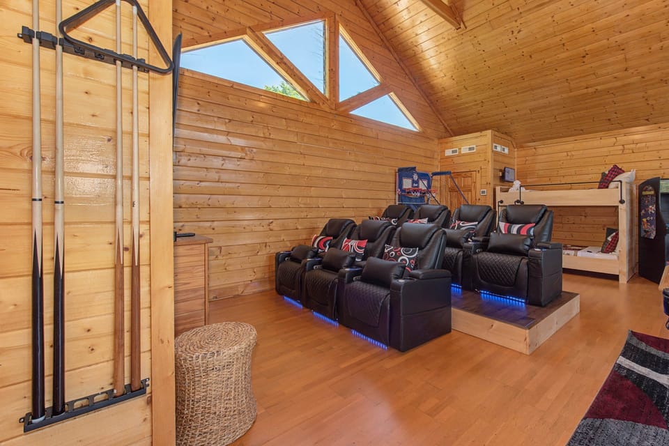 Theater room with leather recliners and pool cue rack — entertainment hub for the whole crew