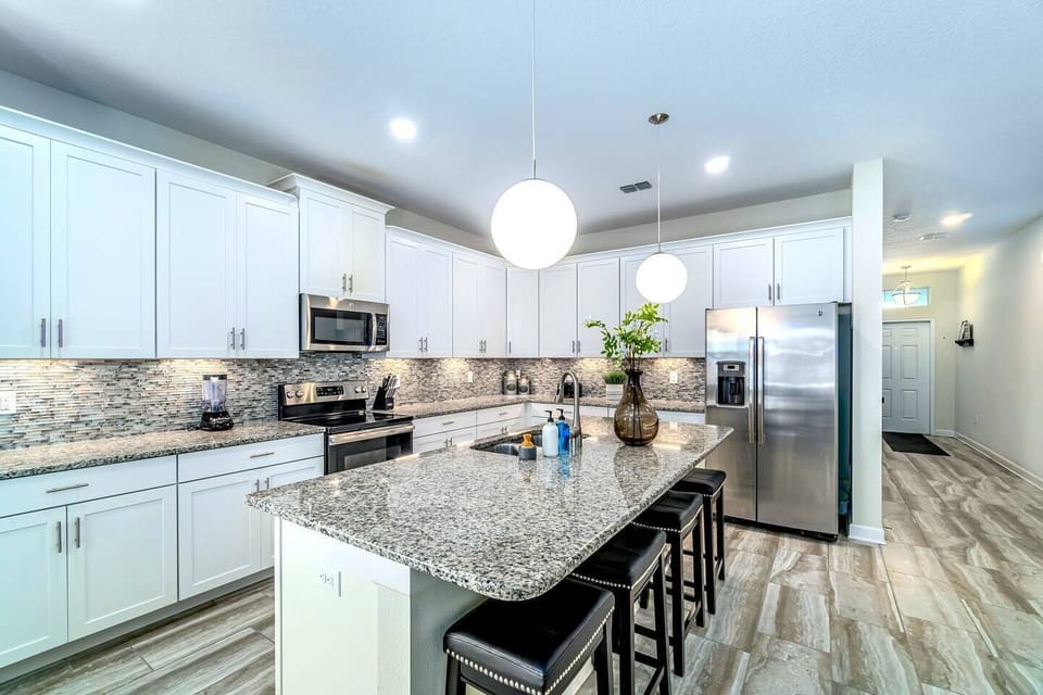 Beautiful high-end kitchen for the family to gather around. Stainless steel appliances and island/bar.
