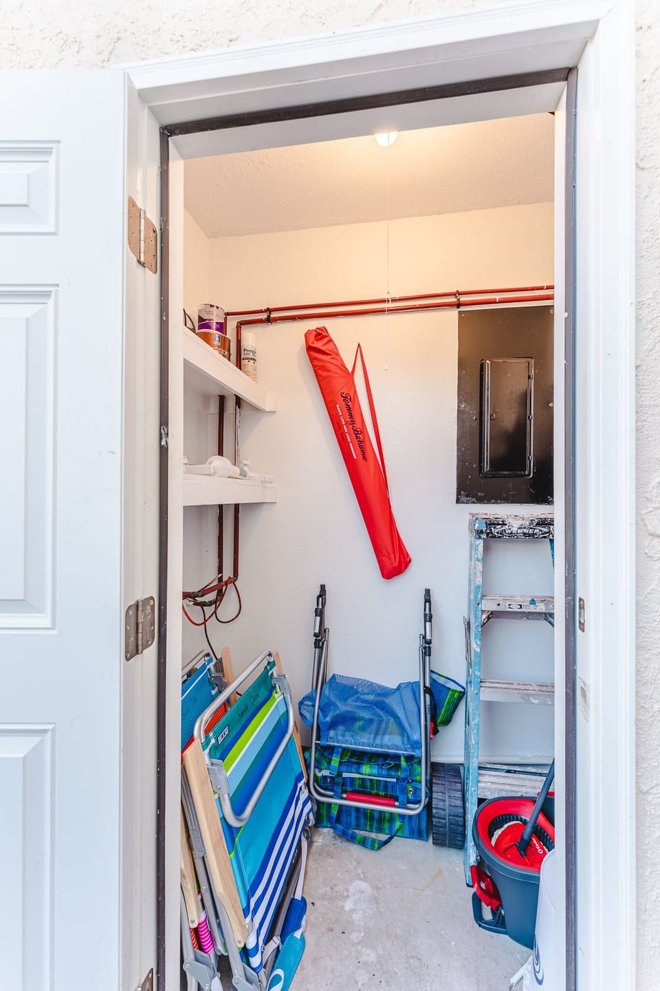 Utility closet with 4 beach chairs, beach umbrella and beach cart