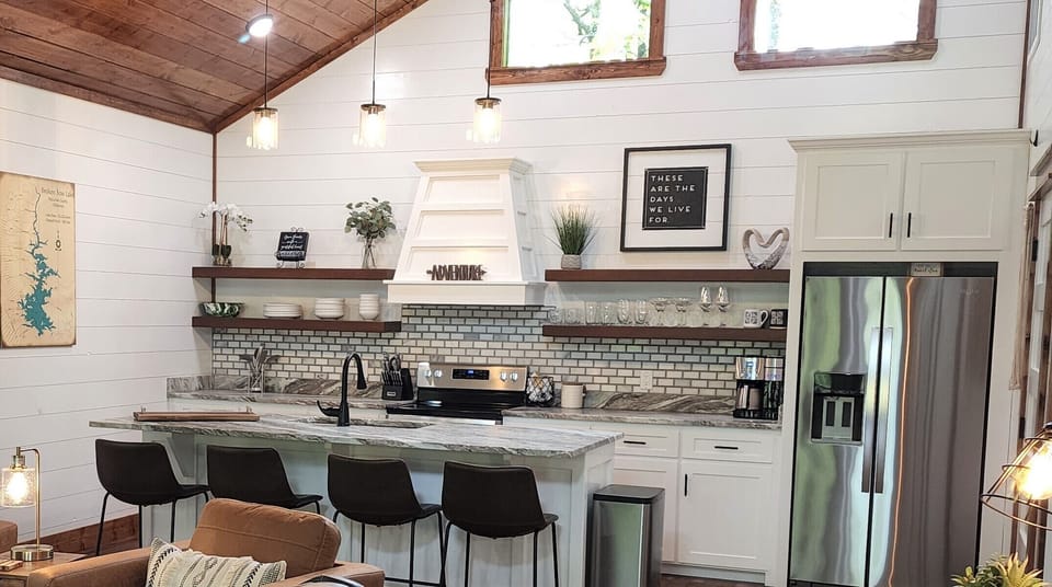 Open concept, fully stocked kitchen with very large bar and 4 bar stools