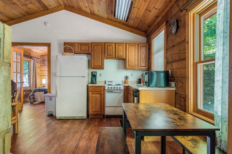 Cook with ease in a fully stocked kitchen featuring wood cabinetry, modern appliances, and a dining area—everything you need for meals at home.