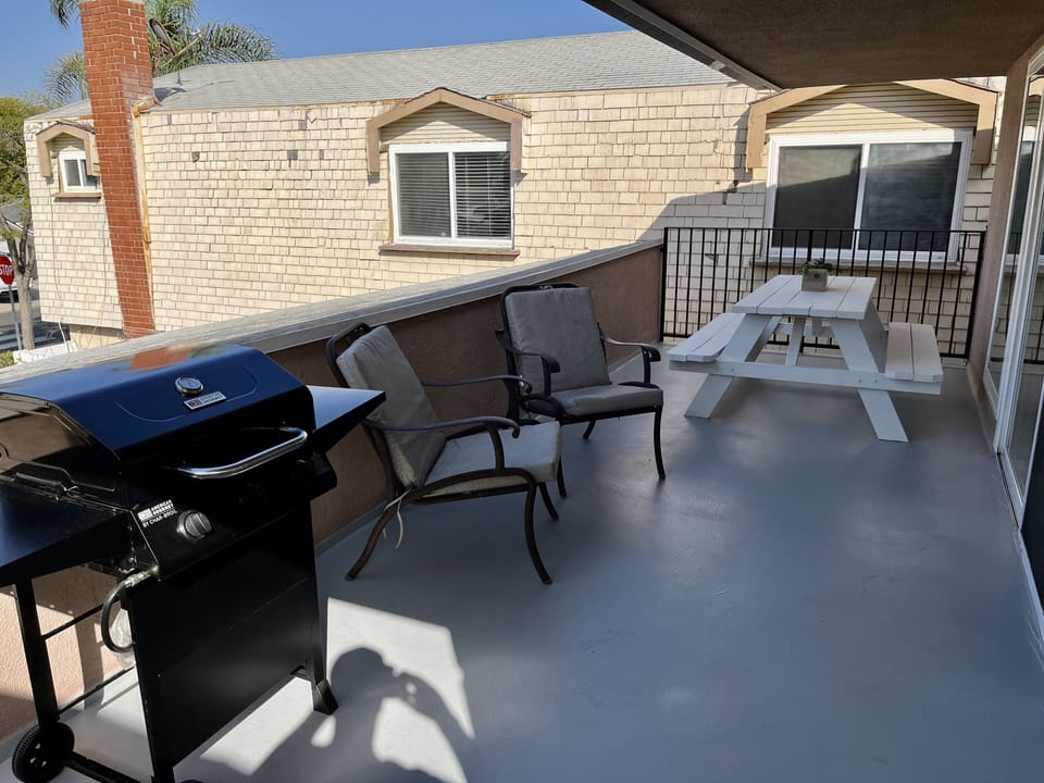 Upstairs Unit: Patio with picnic dining table, chairs and BBQ propane grill