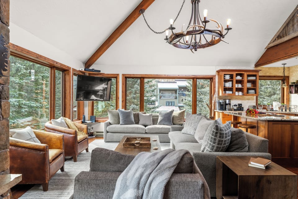 Bright living room with TV and chandelier.