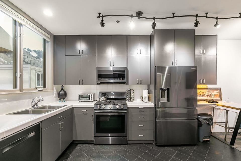 Modern kitchen with track lighting, tons of prep space, and a gas stove.