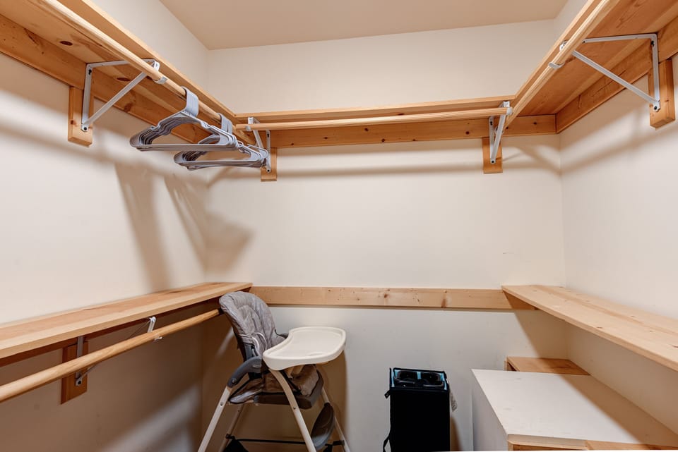 Baby highchair and Pack 'N Play crib in the master bedroom walk-in closet