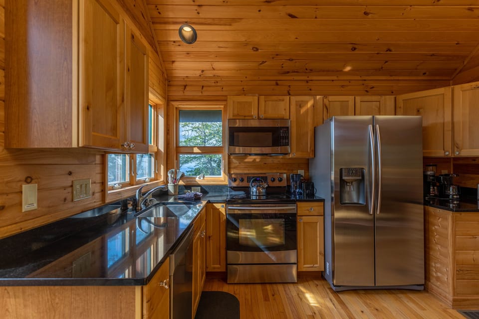 Fully equipped kitchen with warm pine walls and dark granite counters, ready for mountain meals at Chalet At The Summit Of Beech.