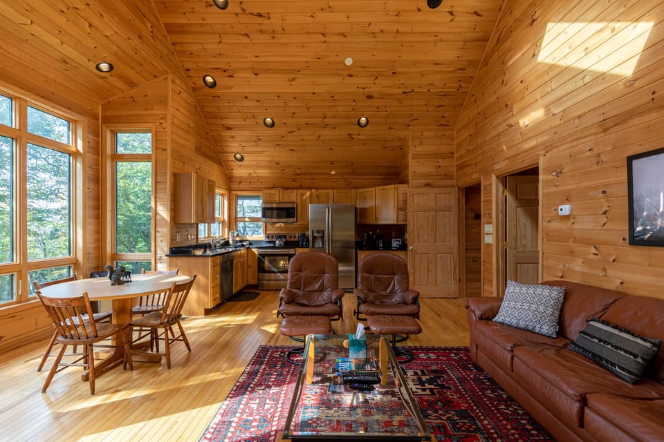 Warm knotty pine throughout, leather recliners, and treetop light pouring in. One great room to relax, dine, and gather.