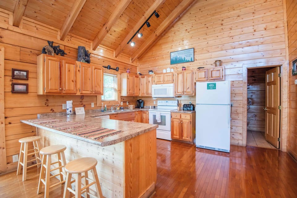 Fully equipped kitchen with ample counter space and rustic cabin charm.