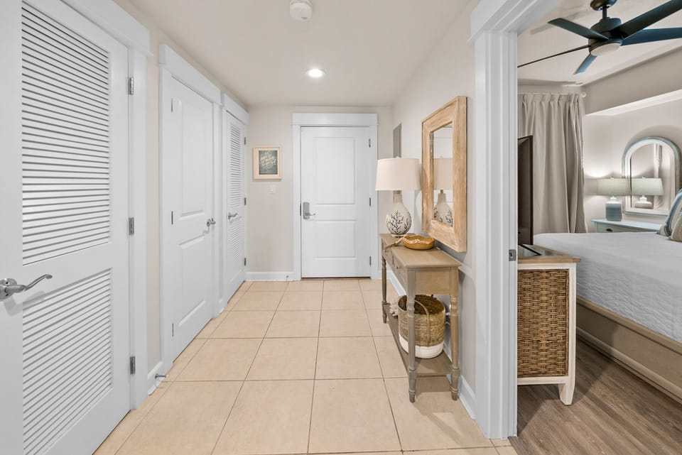 Your bright, airy bedroom hallway features beautiful coastal decor and plenty of storage with white louvered doors throughout.