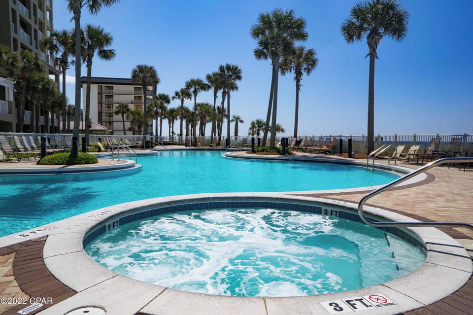 Soak up the tropical atmosphere at this stunning pool complex, complete with bubbling hot tub and swaying palms creating your perfect oceanside retreat.