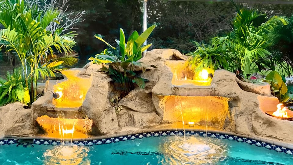Lighted waterfall with fire feature gives a tropical oasis vibe!