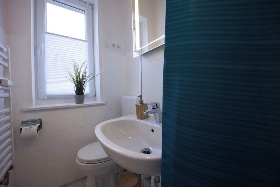 Badezimmer mit beleuchtetem Spiegel.