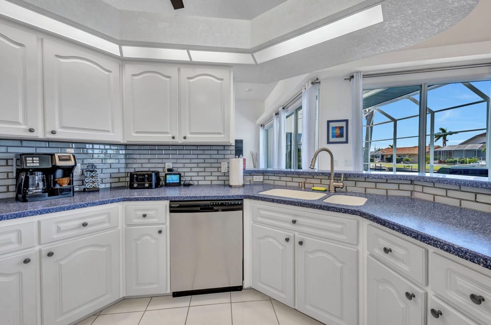 OPEN KITCHEN WITH TROPICAL FLORIDA VIBE HAS VIEWS TO POOL AMD WATERFRONT