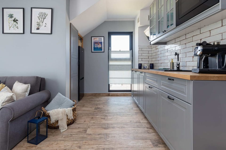 A living space featuring a comfortable sofa, stylish coffee table, and a door leading to the kitchen area.