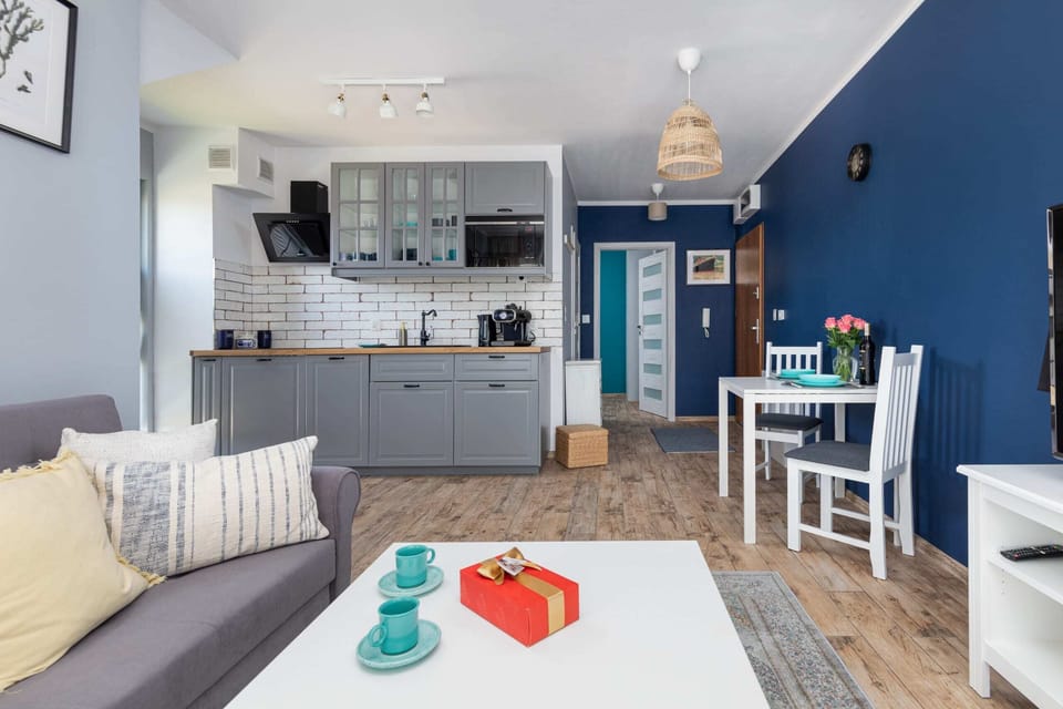 A modern bedroom featuring a double bed with grey and white bedding, complemented by decorative throw pillows.
