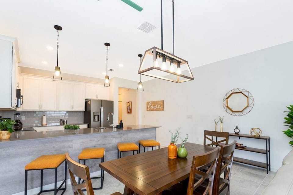 This house is equipped with a spacious and elegant dining room, completed with comfortable chairs for the family to relax in after a long day at the parks.