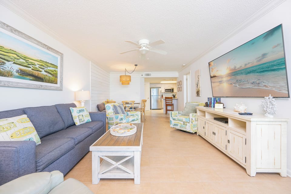 Relax in the inviting living area featuring a queen sleeper sofa and a beachfront balcony
