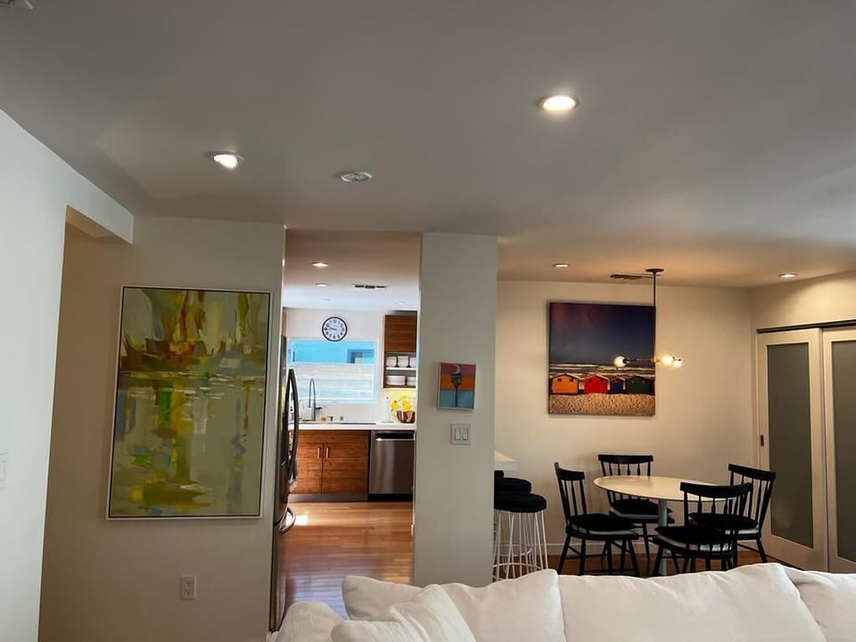 Kitchen entrance flanked with beautiful beach themed paintings 