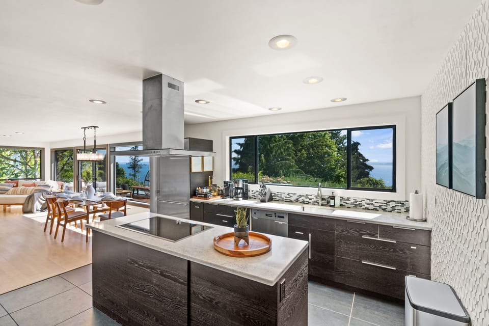 Fully stocked modern kitchen with induction stove top, double oven, coffee bar.