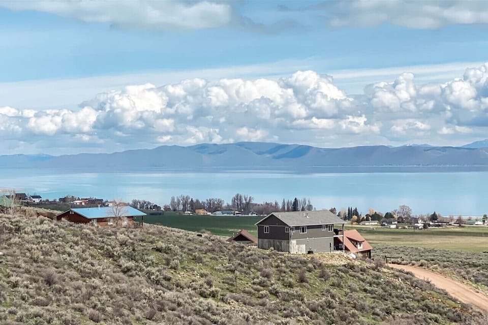 Peaceful hillside views overlooking a sparkling lake and majestic mountains—your perfect retreat awaits.