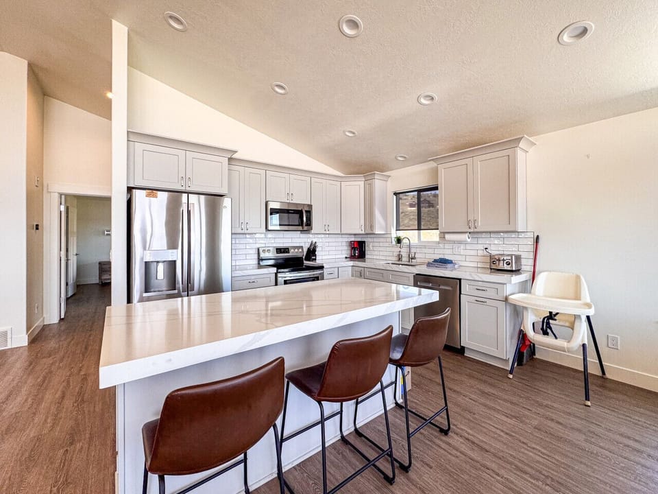 Bright, modern kitchen with spacious island, stainless steel appliances, and perfect setup for family gatherings.