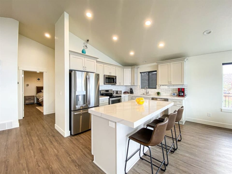 Bright, modern kitchen with spacious island, stainless steel appliances, and perfect setup for family gatherings.