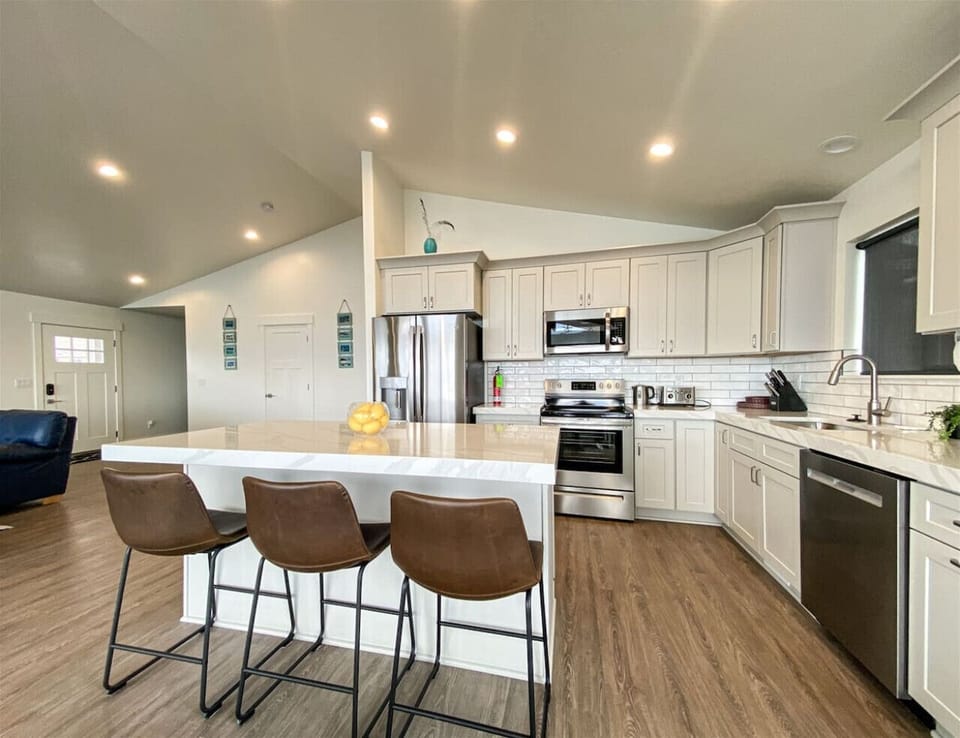 Bright, modern kitchen with spacious island, stainless steel appliances, and perfect setup for family gatherings.
