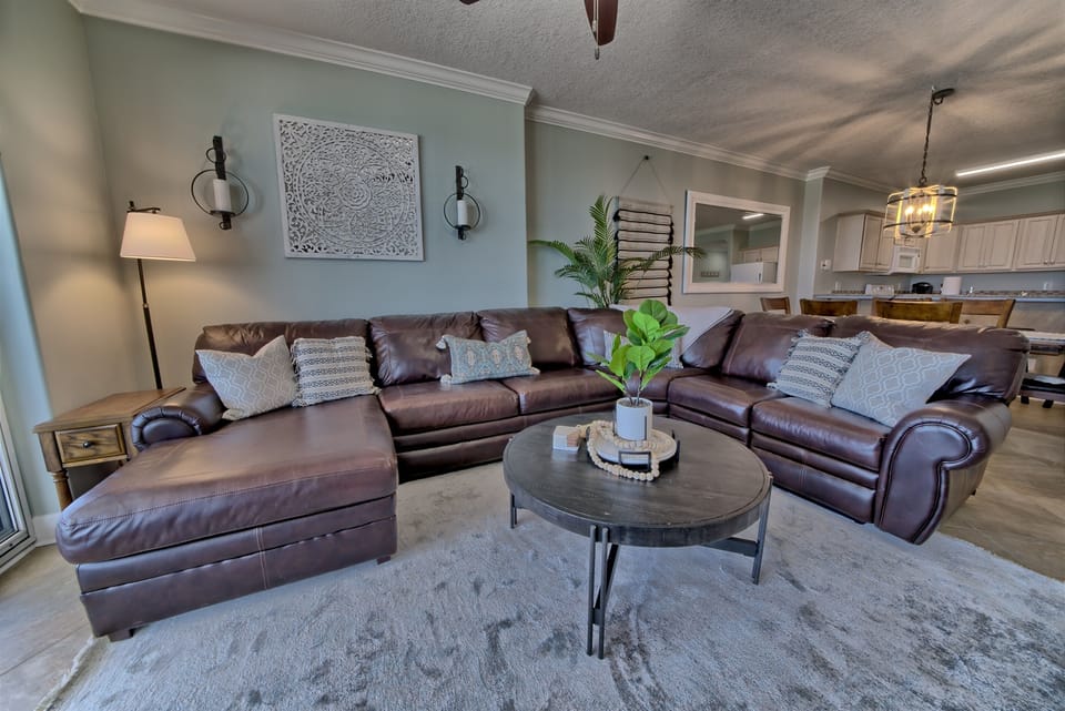 Living room has a comfortable sectional with a reclining chair on the end and a sleeper sofa