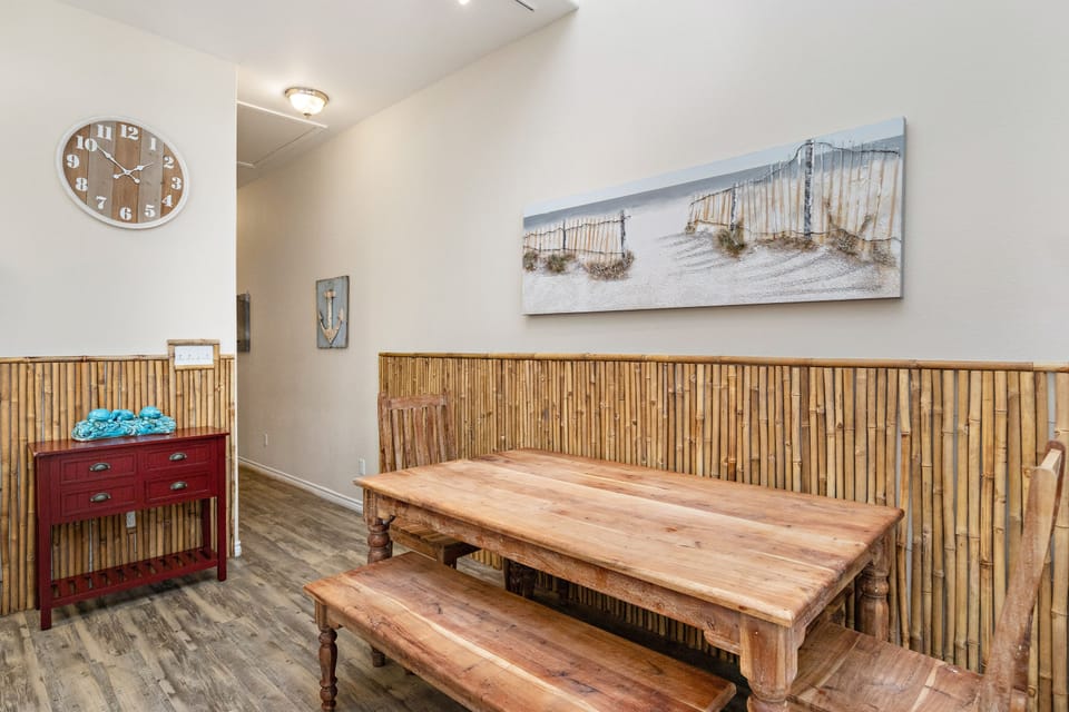 Unwind in your coastal-themed dining area featuring warm bamboo walls and beach artwork that brings the ocean indoors.
