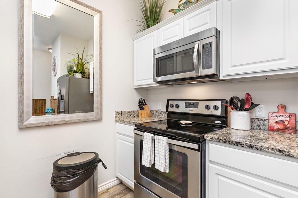 Your fully equipped kitchen awaits with granite counters, stainless appliances, and thoughtful touches like fresh plants to inspire your culinary adventures.