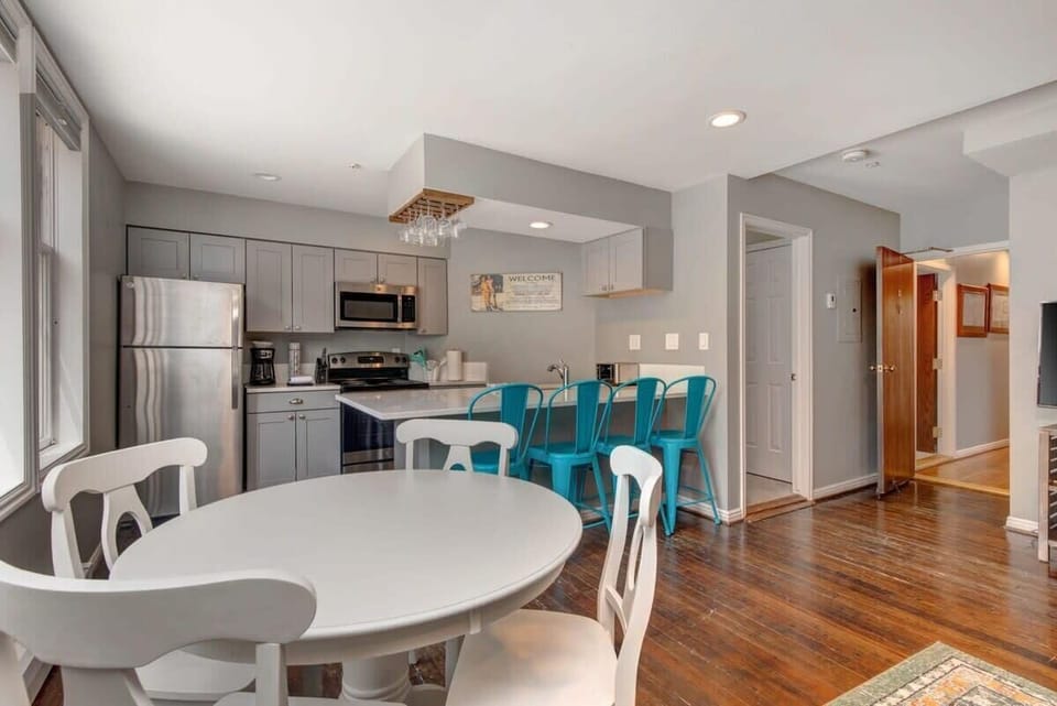 The dining and kitchen areas in this bright and beautiful home, boasting seating for eight between the bar and dining table. Loads of light, stainless steel appliances and stylish finishes are found throughout the kitchen.