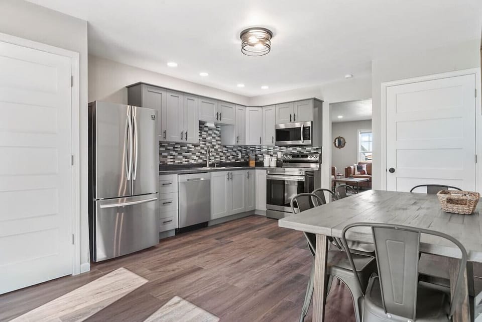 The kitchen is fully equipped for all your cooking needs, featuring a refrigerator, oven, stove, coffee maker, and a full set of kitchen utensils.