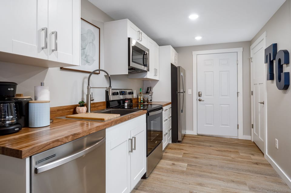 Sleek kitchen layout w/ modern appliances, wood countertops & everything within easy reach.