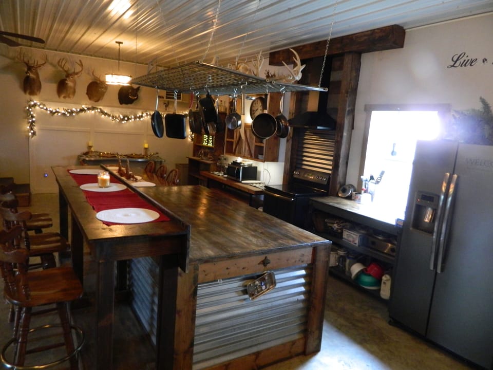 Bar seating on Island. Pots and pans are hanging above.