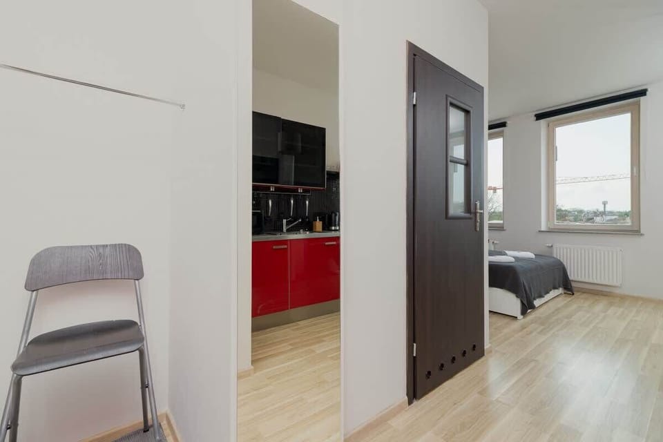 A small bedroom featuring a gray bedspread, white closet doors, and modern decor.