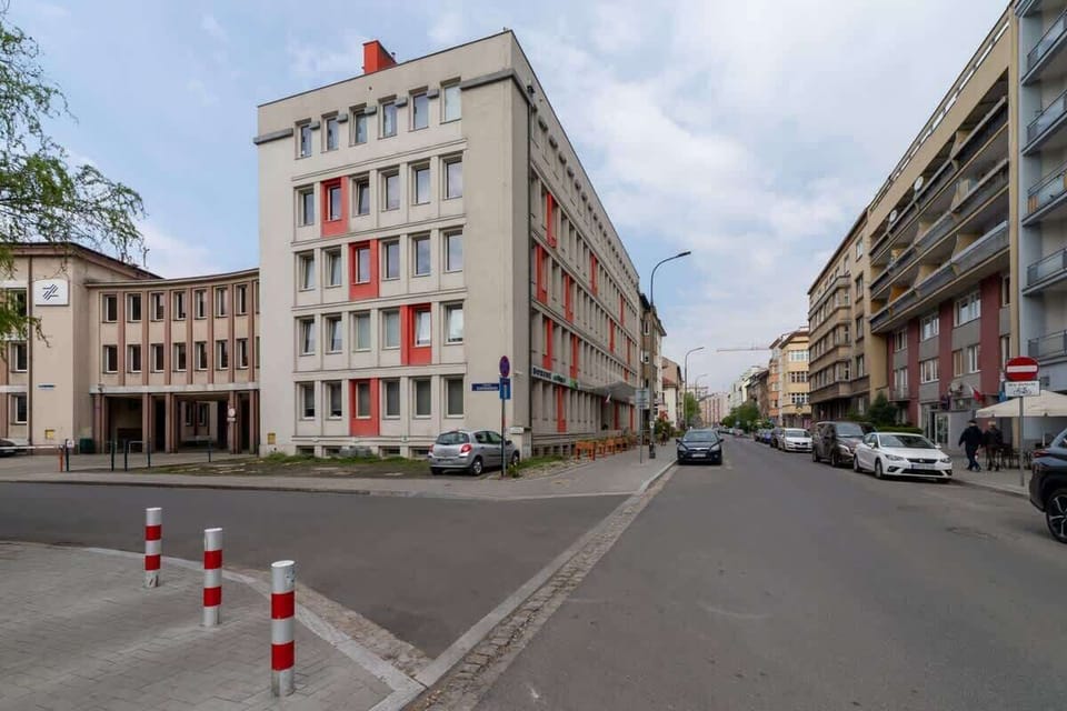Another angle of a city street showing parked cars and mid-rise residential buildings.