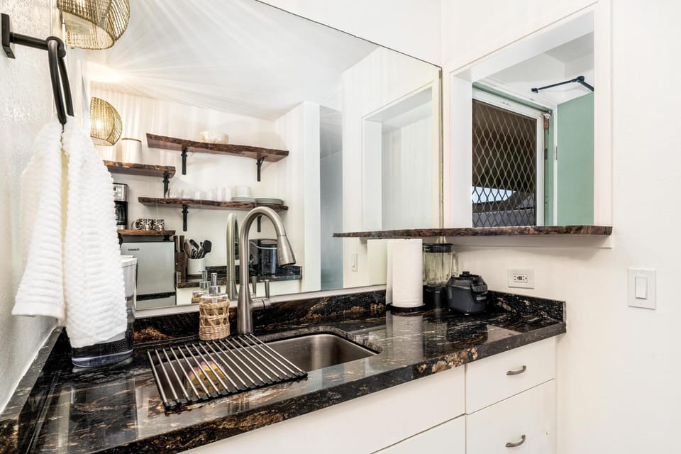 Your fully equipped kitchen features elegant granite countertops, open shelving with rustic charm, and everything you need to prepare delicious meals during your stay.