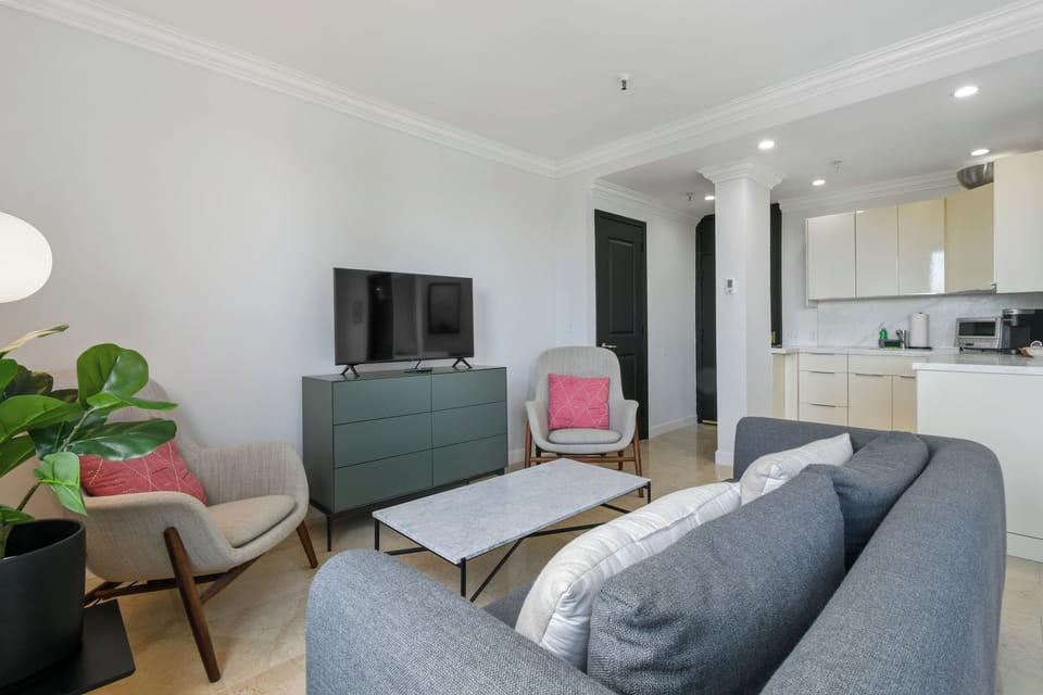 Spacious studio suite with a king-size bed, modern decor, seating area, and natural light