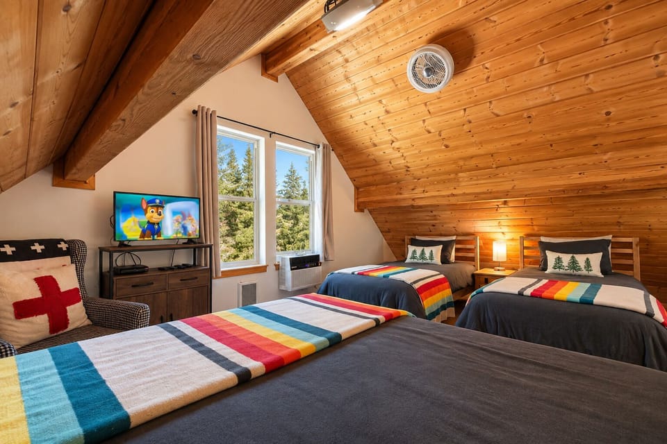Upper Level Sleeping Loft with TV with DVD, window AC and two twin beds and one queen bed.