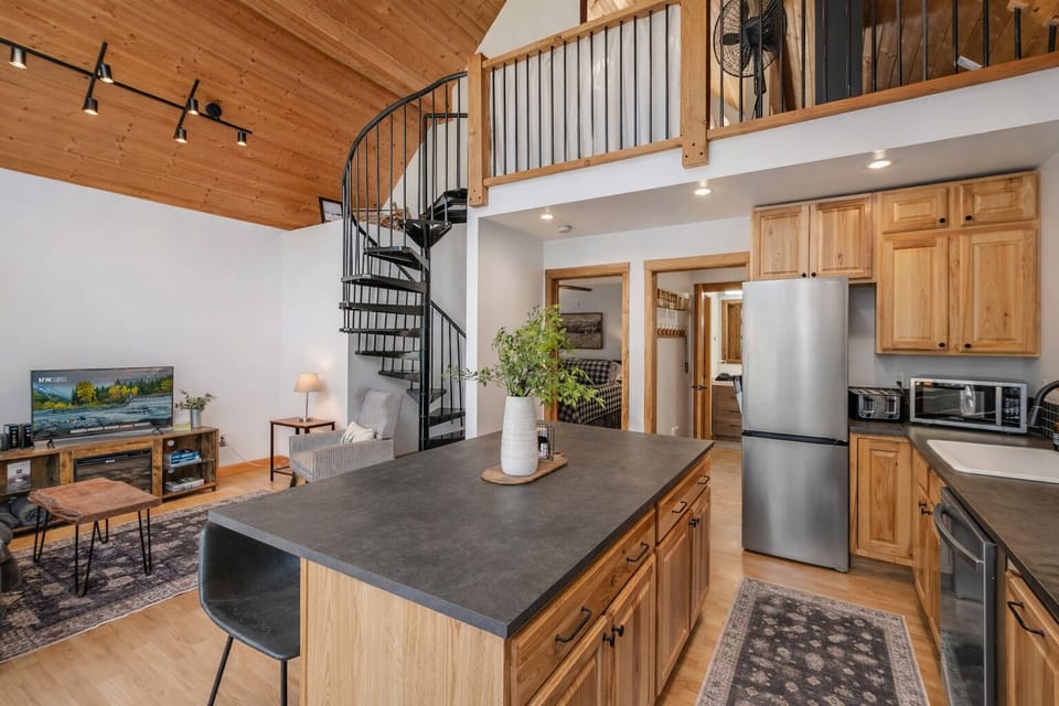 Gather around the spacious kitchen island while natural wood touches and soaring ceilings create your perfect mountain retreat atmosphere.