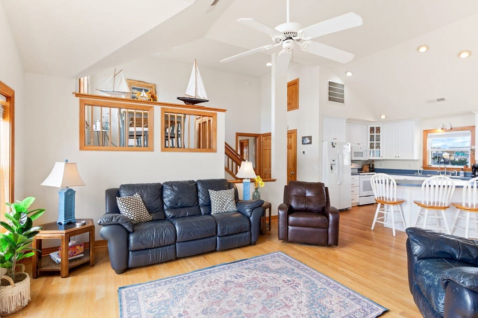 Top-Level Living Area: Bright and airy space with cathedral ceilings, LVP flooring, comfortable furnishings, and large flat-screen TV.